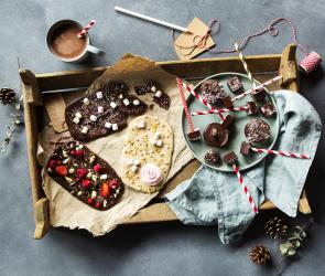 Bruchschokolade mit bunten Topping auf einem Holztablett.