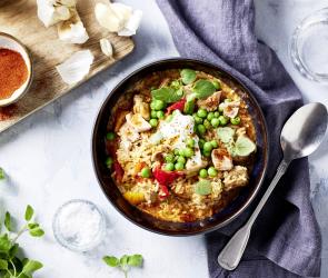 Reis mit Erbsen und Paprika in einer Schüssel.