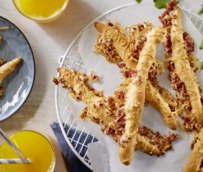 Knusprige Käsestangen mit kleinen Salamistücken.