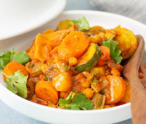 Gemüse-Tajine mit Staudensellerie, Steckrüben, Zucchini, Karotten, Kichererbsen und Couscous.