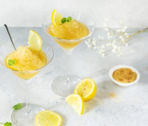 Granita Siciliana serviert in Cocktailgläsern garniert mit Zitronen.