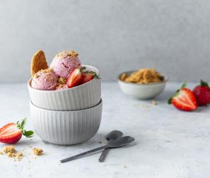 Strawberry-Cheesecake-Eis zu Kugeln portioniert in einer Schüssel.