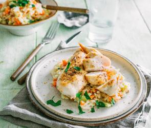 Gedämpftes Hähnchen mit Krautsalat serviert auf einem gedeckten Tisch.