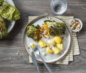 Vegane Krautwickel mit Kürbis-Nuss-Füllung angerichtet mit Kartoffeln