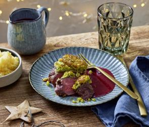 Rinderfilet mit Knusperkruste auf einem roten Soßenspiegel.