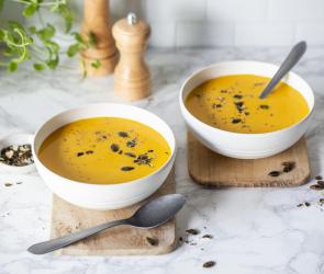 Cremige Kürbissuppe in Schalen garniert mit Kürbiskernen