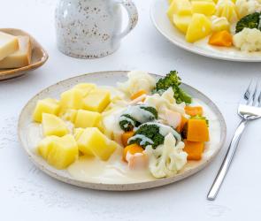 Kartoffeln mit buntem Gemüse und Käsesauce.