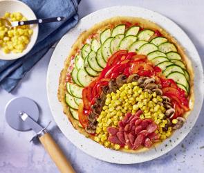 Schnelle Pfannenpizza ohne Hefe belegt mit buntem Gemüse.