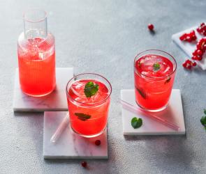 Johannisbeer-Limonade in Gläsern mit Minze dekoriert.