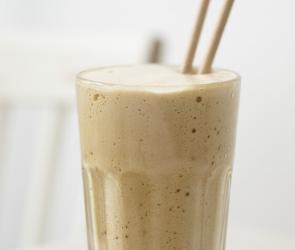 Kaffee frapé in einem Glas mit Milchschaum.