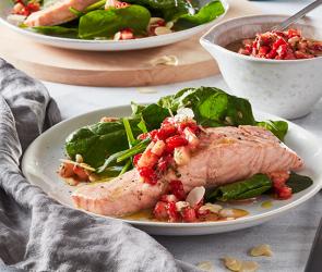 Lachs mit Spinat und Erdbeeren auf zwei Tellern angerichtet.