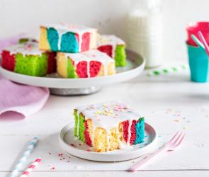 Bunter Papageienkuchen mit Zuckerguss in Stücke geschnitten.