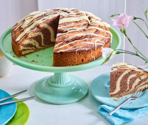 Zebrakuchen auf eiem Tortenständer, angeschnitten.