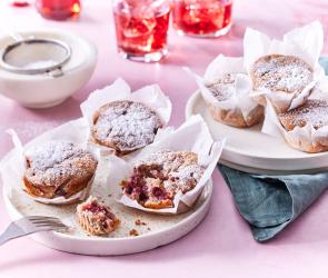 Kirschmuffins auf einem rosafarbenen Untergrund.