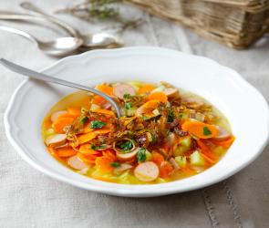 Karotteneintopf mit gerösteten Zwiebeln auf einem gedeckten Tisch.