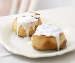 Zimt-Walnuss-Schnecken mit Zuckerguss auf einem Teller.