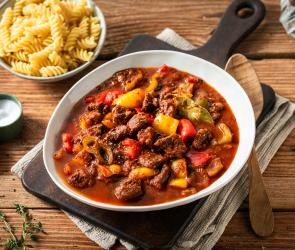 Buntes Paprikagulasch in tiefem Teller mit Nudeln