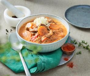 Rouladen Topf mit Gemüse in einem tiefen Teller auf einem Tisch.