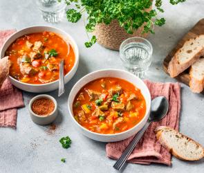 Paprikatopf mediterran mit Rind in Schüsseln auf einem gedeckten Tisch.