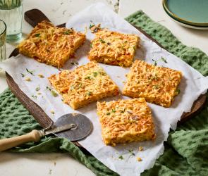 Schüttelpizza in Stücke geschnitten auf eine Brett.