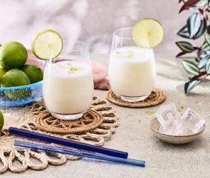 Brazilian Lemonade in cremeweiß in zwei Gläsern mit Limettenscheiben.