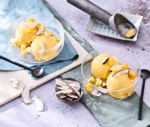 Mango-Kokos-Eis in Kugeln in Glasschälchen.