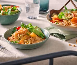 Sommerrollen Salat in Schüsseln mit buntem Gemüse.