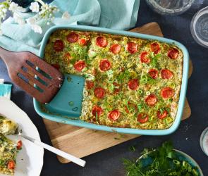 Gemüse Gratin mit Tomaten und Kräutern in einer Auflaufform.