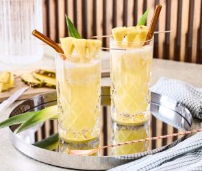 Vigin Pinacolada mit frischer Ananas als Deko in zwei Gläsern mit Stohhalmen.