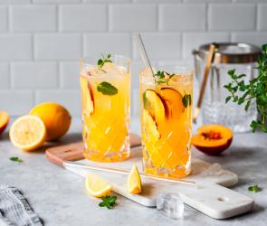 Pfirsich Limonade mit frischen Pfirsichen und Minze in Gläsern.