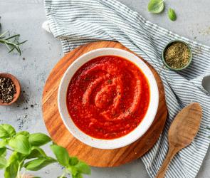 Pizzasauce in einer weißen Schale mit Basilikum.