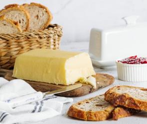 Butter selbstgemacht auf einem Brett mit frischem Brot.