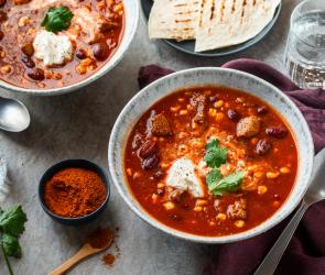 Mexikanischer Bohneneintopf mit Brot in Schüsseln.