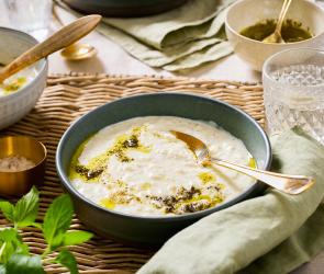 Türkische Joghurtsuppe (Yayla çorbası) in einem tiefen Teller auf einem gedeckten Tisch.