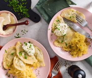 Pierogi mit Sauerkraut gefaltete Teigtaschen auf rosa Tellern.