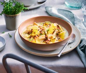 Steckrüben-Pastinaken-Eintopf mit Hähnchen in einem tiefen Teller.