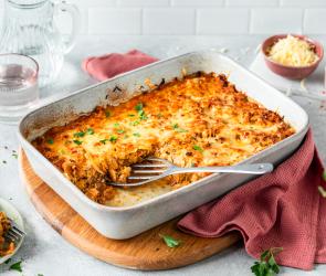 Weißkohlauflauf mit Käse überbacken in einer weißen Auflaufform.