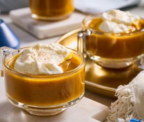 Heißer Butter-Rum mit Kürbis mit Haube in Glastassen.