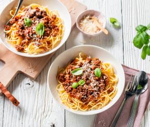Einfache Spaghetti Bolognese auf Tellern garniert mit Basilikum
