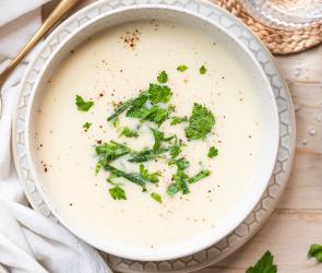 Schnelle Kohlrabicremesuppe mit Kräutern in hellen Schalen.