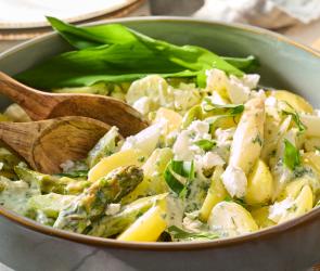 Kartoffelsalat mit Spargel und Bärlauch in einer Salatschüssel.