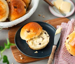 Rosinenbrötchen aufgeschnitten auf einem Frühstücksteller.