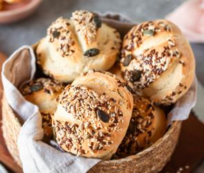Selbstgemachte Brötchen mit Körnern und Samen in einem Brotkorb.