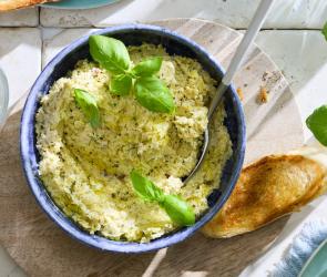 Artischocken Dip mit Basilikum und Baguette.