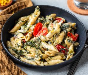 One-Pot-Pasta mit Spinat in einem schwarzen tiefen Teller