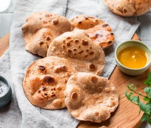Chapatis (Indisches Fladenbrot) luftig ausgebacken auf einem Tuch.