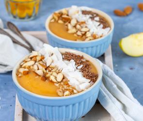 Smoothie Bowl in Schüsseln mit Kokosflocken und Nüssen garniert