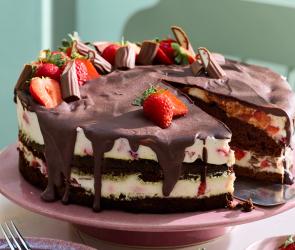 Yogurette-Torte nit frischen Erdbeeren und Schokolade garniert.