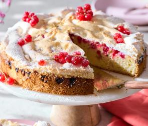 Johannisbeerkuchen mit Baiser auf einer Tortenplatte.