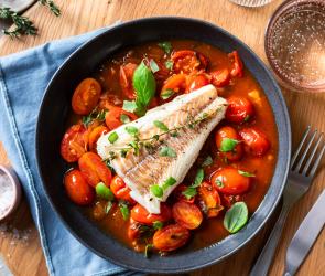 Kabeljau Filet auf Tomaten Sauce auf einem Teller.